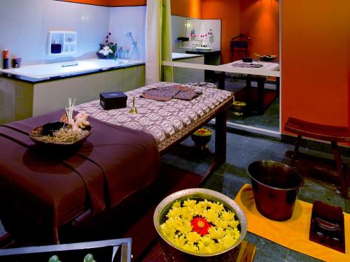 a living room with a table and a kitchen at Novotel Semarang in Semarang