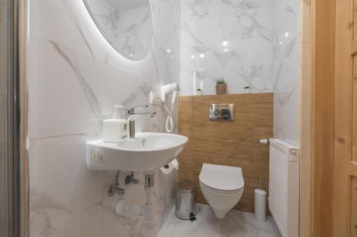 a white bathroom with a sink and a toilet at Tatrzański 22 - Komfortowy dom w górach in Leśnica