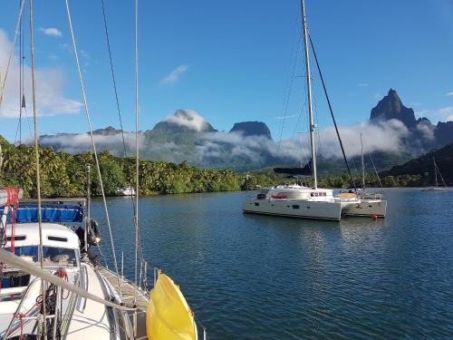 two boats docked in a lake with mountains in the background at 2 nuits insolites & 1 excursion voile à bord du voilier Mori Ora in Orufara