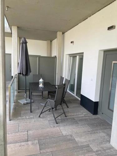 a patio with a table and chairs and an umbrella at Ferienhof Elbaue in Schönebeck