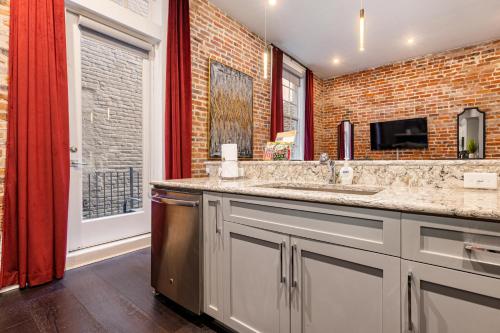 uma casa de banho com um lavatório duplo e uma parede de tijolos em The Napoleon em Nova Orleans