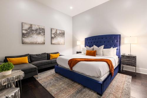 um quarto com uma cama azul e um sofá em The Napoleon em Nova Orleans