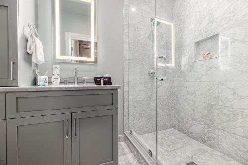 W łazience znajduje się szklana kabina prysznicowa i umywalka. w obiekcie The Crescent w Nowym Orleanie