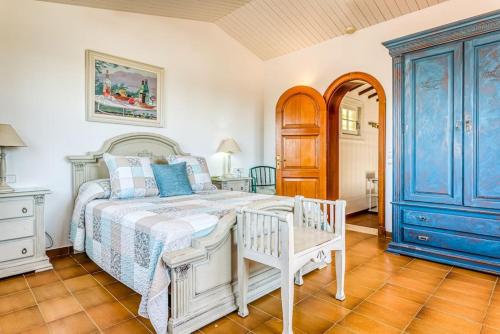 a bedroom with a white bed and blue cabinets at LA CALMA Espectacular villa con jardín y piscina en Menorca in S'Algar