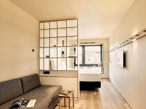 a living room with a couch and a bedroom at Schwabinger Wahrheit by Geisel in Munich
