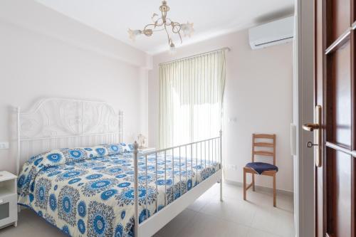 una camera con un letto e una sedia e una finestra di Solemar Sicilia - Casa Butera a Bagheria