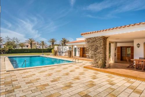 a villa with a swimming pool and a patio at LA CALMA Espectacular villa con jardín y piscina en Menorca in S'Algar