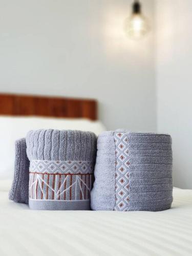 two towels sitting on top of a bed at Mahkota Pool View Apartment near A’Famosa & Jonker in Melaka