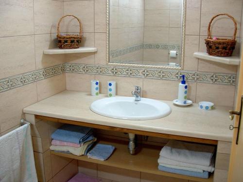 La salle de bains est pourvue d'un lavabo, d'un miroir et de serviettes. dans l'établissement Villa De Rêve avec Piscine XXL Vue Panoramique, à Fundão
