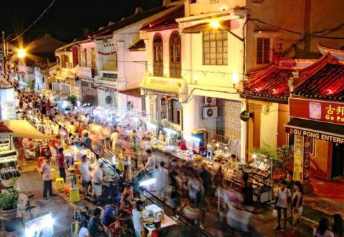 a crowd of people walking around a street at night at Mahkota Pool View Apartment near A’Famosa & Jonker in Melaka