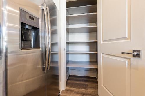 a kitchen with a stainless steel refrigerator and shelves at The Bonaparte in New Orleans