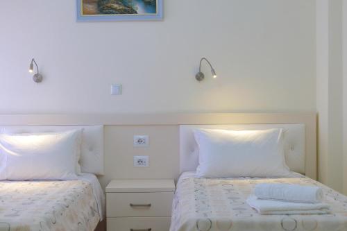 a bedroom with two beds with white pillows at Sunny Holiday in Sarandë