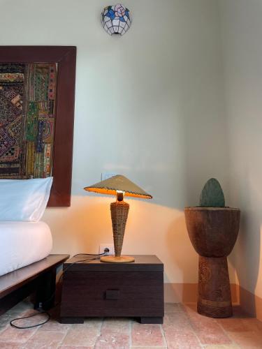 a lamp on a table next to a bed at Pioppi Neri R&B in Felino