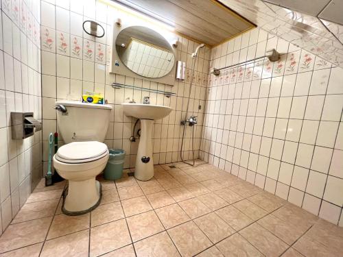 a bathroom with a toilet and a sink at Fengjia Pig's House in Taichung