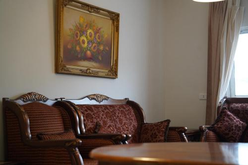 a room with chairs and a painting on the wall at Mahfouz Suite - Ajloun's downtown in Ajloun