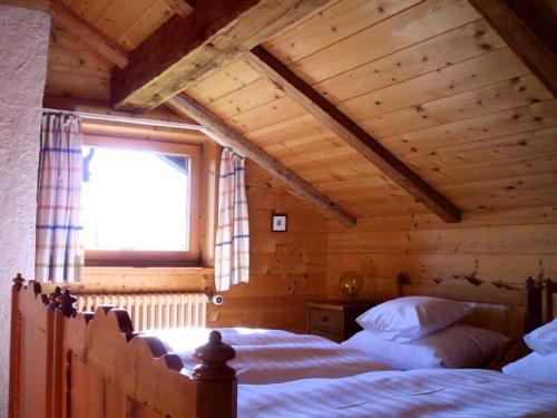a bedroom with a large bed in a wooden house at Knusperhäusle Reckenberg in Bad Hindelang