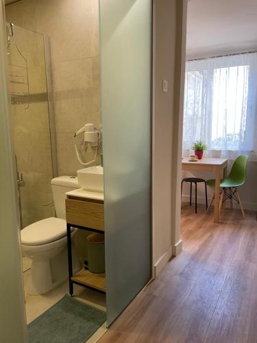 a bathroom with a toilet and a sink and a table at ak apartments in Athens