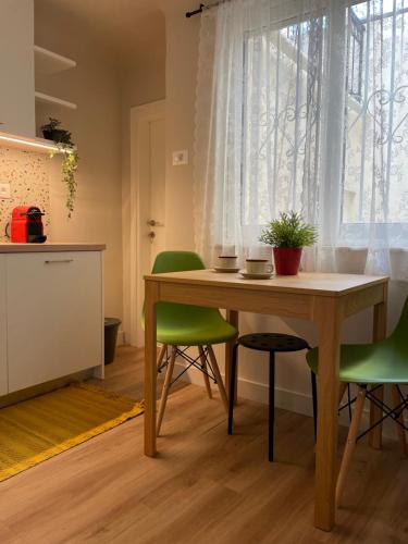 a dining room with a wooden table and green chairs at ak apartments in Athens