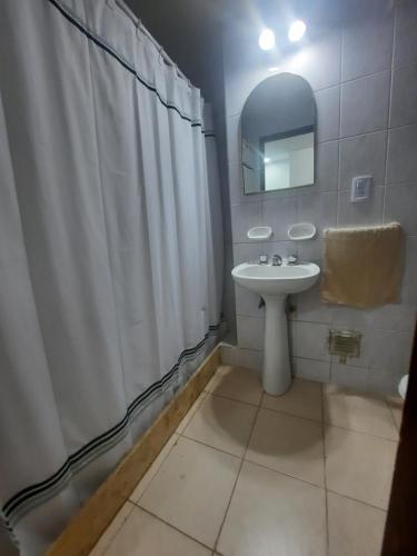 baño con cortina de ducha blanca y lavamanos en Pleno centro en San Juan