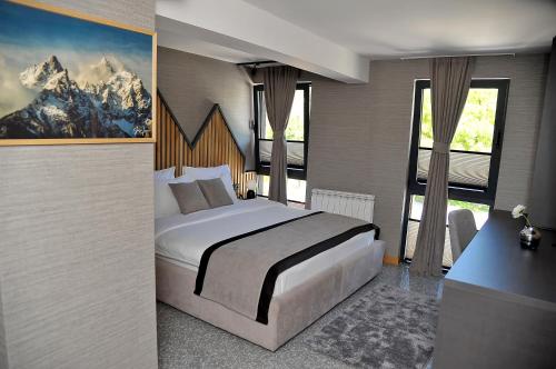 sypialnia z dużym łóżkiem i dużym oknem w obiekcie Modern Mountain w mieście Kolašin