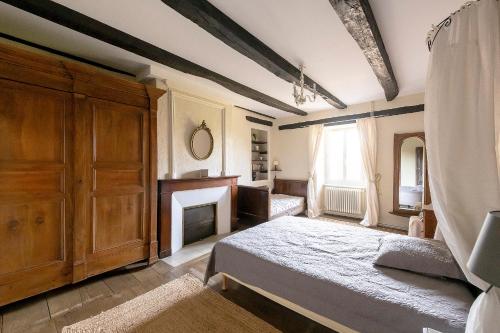 a bedroom with a bed and a fireplace at Le Clos d'Albray - Chambres d'hôtes et gite in Comps-la-Grand-Ville