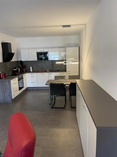 a kitchen with a table and a red chair in it at Ferienhof Elbaue in Schönebeck