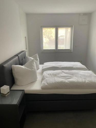 a large bed with white sheets and a window at Ferienhof Elbaue in Schönebeck