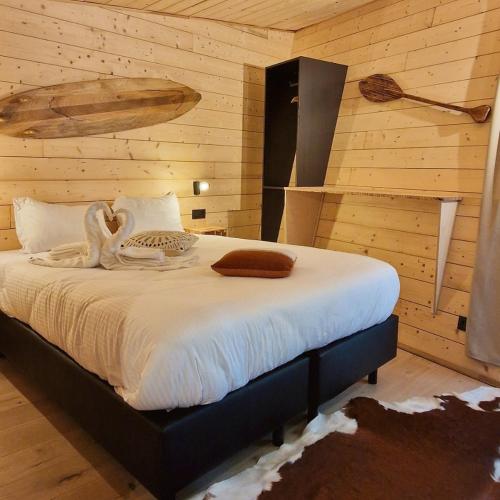 a bedroom with a bed with a wooden wall at Utopia Village - Art & Nature Lodges in Mons