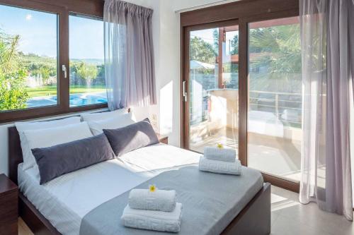 sypialnia z łóżkiem i dużym oknem w obiekcie Villa David Heraklion w mieście Kavrokhórion
