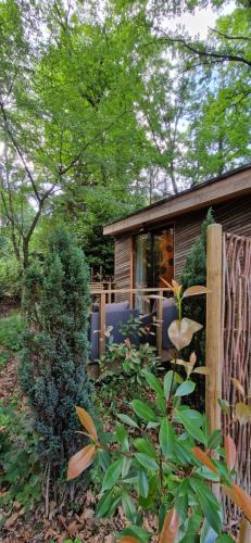 a small house in a garden with a fence at Utopia Village - Art & Nature Lodges in Mons