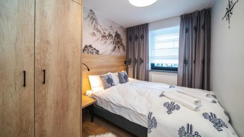 um quarto com uma cama e um armário de madeira em Apartamenty Sun & Snow Resorts J Białka Tatrzańska z sauną em Białka Tatrzanska