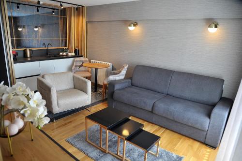 a living room with a couch and a kitchen at Modern Mountain in Kolašin