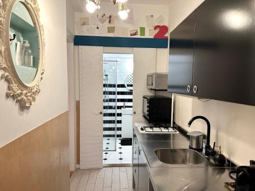 Twenty2 Apartment في بودابست: مطبخ صغير مع حوض ومرآة