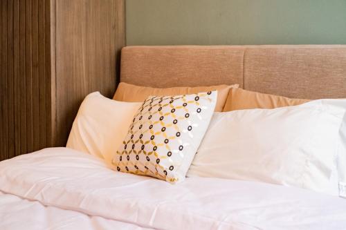 a bed with white sheets and a pillow on it at Grand Residences Cebu ETB - Near IT Park and Ayala Cebu in Cebu City