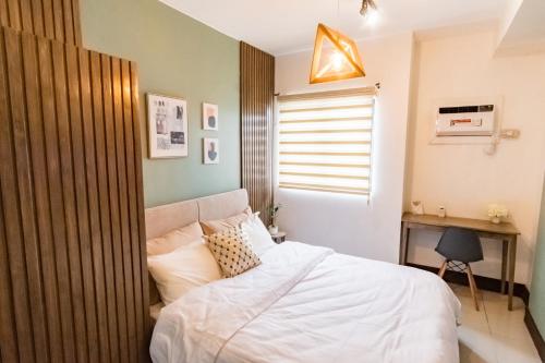 um quarto com uma cama branca e uma janela em Grand Residences Cebu ETB - Near IT Park and Ayala Cebu em Cebu