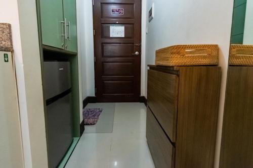a small kitchen with a wooden door and a hallway at Grand Residences Cebu ETB - Near IT Park and Ayala Cebu in Cebu City