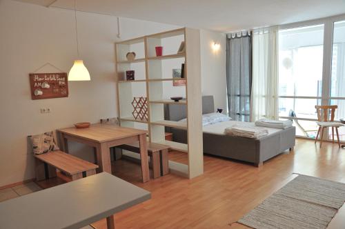 ein Wohnzimmer mit einem Bett und einem Tisch in der Unterkunft Steinkogler Ferienwohnungen in Ebensee