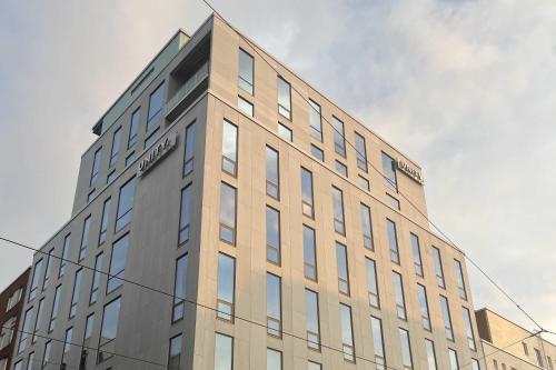 a tall building with a sign on the side of it at Unity Helsinki - A Studio Hotel in Helsinki