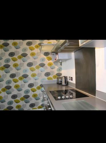 a kitchen with a counter top with umbrellas on the wall at Empire apartment in Huddersfield