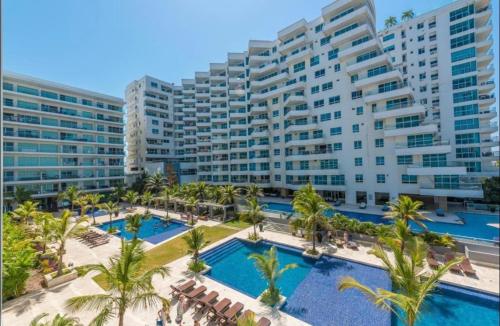 um grande edifício de apartamentos com piscina e palmeiras em MORROS EPIC 1111 em Cartagena de Indias