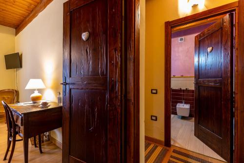 a room with a wooden door and a desk and a table at Affittacamere Is Coronas in Ìsili