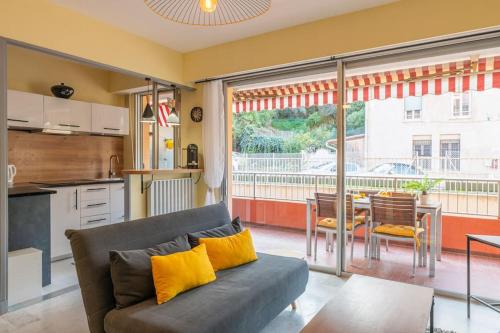 Il comprend un salon avec un canapé, une cuisine et une table. dans l'établissement Cosy Studio près des Palaces Mentonnais, à Menton