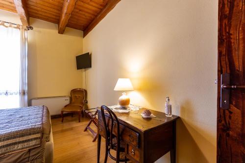 a bedroom with a desk with a lamp and a bed at Affittacamere Is Coronas in Ìsili