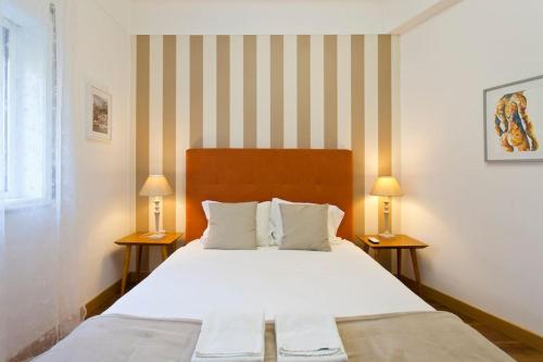 een slaapkamer met een groot wit bed met 2 lampen bij APOSENTUS - Serenity 1D in Porto