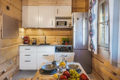 a kitchen with white cabinets and a table with fruit on it at Pienińska Przystań in Kluszkowce