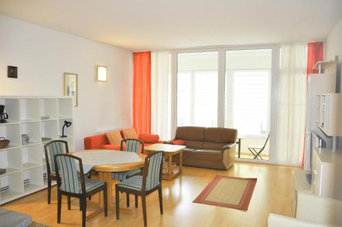 sala de estar con mesa, sillas y sofá en Steinkogler Ferienwohnungen, en Ebensee
