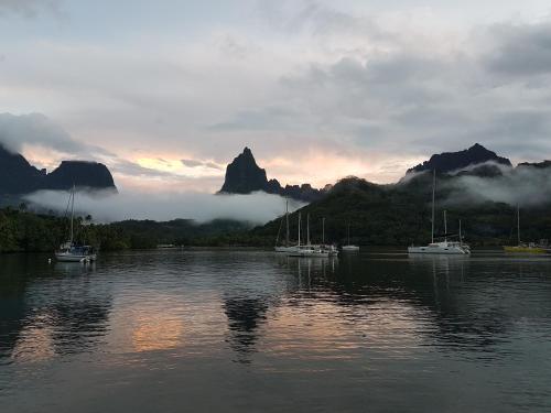 un groupe de bateaux assis sur un lac avec des montagnes dans l'établissement 2 nuits insolites & 1 excursion voile à bord du voilier Mori Ora, à Orufara