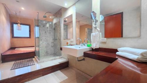 a bathroom with a shower and a sink and a tub at House Park Hotel Boutique in Santa Fe