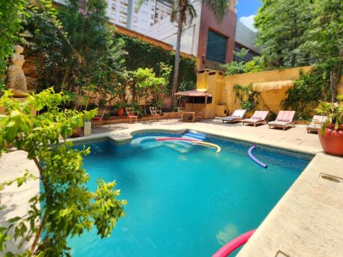 uma grande piscina com água azul num quintal em House Park Hotel Boutique em Santa Fé