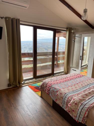 a bedroom with a bed and a large window at Wineyards Salin in Turda